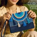 Aegean Boho Bag χειροποίητο τσαντάκι χειρός από τζιν ύφασμα με πλεκτό ματόχαντρο, φούντες και φερμουάρ