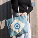 Χειροποίητη boho τσάντα παραλίας με ελληνικό ματάκι για το καλοκαίρι. Γαλάζιο χρώμα, κροσέ λεπτομέρειες και πον-πον. Ιδανική για τις διακοπές.