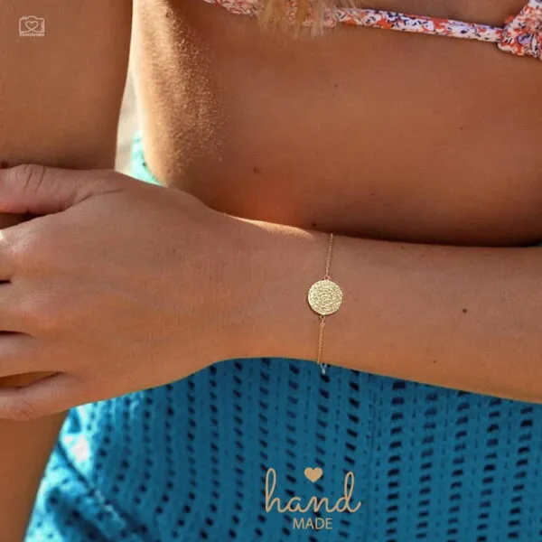 Το Phaistos Bracelet, εμπνευσμένο από τον μυστηριώδη και εμβληματικό Δίσκο της Φαιστού, ένα από τα σημαντικότερα αρχαιολογικά ευρήματα της μινωικής Κρήτης, το βραχιόλι αυτό αποτυπώνει τη διαχρονική γοητεία και τη δύναμη της αρχαίας ελληνικής κληρονομιάς. Το κυκλικό στοιχείο στο κέντρο του κοσμήματος φέρει το χαρακτηριστικό ανάγλυφο μοτίβο του δίσκου, σύμβολο πολιτισμού, ιστορίας και αισθητικής αρμονίας. Κάθε κομμάτι είναι χειροποίητο, κατασκευασμένο από ασήμι 925°, με ιδιαίτερη φροντίδα στη λεπτομέρεια και την ποιότητα φινιρίσματος. Η λεπτή αλυσίδα αναδεικνύει διακριτικά το κεντρικό μοτίβο, δημιουργώντας ένα κόσμημα κομψό και ευκολοφόρετο, ιδανικό για καθημερινές εμφανίσεις αλλά και για πιο ιδιαίτερες περιστάσεις. Ο αυξομειούμενος μηχανισμός του επιτρέπει άνετη εφαρμογή και τέλεια προσαρμογή στον καρπό, προσφέροντας πρακτικότητα χωρίς να θυσιάζει την αισθητική. Η ισορροπία ανάμεσα στη μινιμαλιστική γραμμή και τον έντονο συμβολισμό του σχεδίου το καθιστά ένα κόσμημα με χαρακτήρα. Διατίθεται σε τρεις αποχρώσεις: Ασημί Χρυσό Ροζ Χρυσό Είναι ένα κόσμημα που δεν αποτελεί απλώς αξεσουάρ, αλλά μια μικρή ιστορία φορεμένη στον καρπό — μια σύνδεση με το παρελθόν, δοσμένη μέσα από σύγχρονη, εκλεπτυσμένη αισθητική. Ιδανικό ως ξεχωριστό δώρο με συμβολικό χαρακτήρα ή ως προσωπική επιλογή για όσους αγαπούν την ελληνική παράδοση και τη διαχρονική κομψότητα. Λεπτομέρειες Υλικό: Ασήμι 925° Μέγεθος: Αυξομειούμενο (16,5 cm – 18,5 cm / 6.5" – 7.5") Κατασκευή: Χειροποίητο Εγγύηση: Εφόρου ζωής