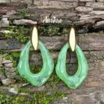 Αναδείξτε τη φινέτσα σας με τα Emerald Drop Earrings σε πράσινο χρώμα με χρυσό φινίρισμα. Κατασκευασμένα από υψηλής ποιότητας ανοξείδωτο ατσάλι, συνδυάζουν την ανθεκτικότητα με την κομψότητα ενός διαχρονικού κοσμήματος. Tο κρεμαστό δάκρυ από κόκκαλο σε έντονο πράσινο χρώμα προσθέτει κίνηση και εκλεπτυσμένη λάμψη σε κάθε σας εμφάνιση. Η αντίθεση του ζεστού χρυσού με το ζωηρό πράσινο δημιουργεί ένα statement κομμάτι που μαγνητίζει τα βλέμματα. BF02.00028