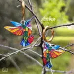 Ατσάλινα σκουλαρίκια κρίκος Auric Colibri με κρεμαστό κολιμπρί σε σχέδιο βιτρώ, πολύχρωμο με χρυσές λεπτομέρειες.