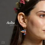 Ατσάλινα σκουλαρίκια κρίκος Auric Colibri με κρεμαστό κολιμπρί σε σχέδιο βιτρώ, πολύχρωμο με χρυσές λεπτομέρειες.