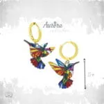 Ατσάλινα σκουλαρίκια κρίκος Auric Colibri με κρεμαστό κολιμπρί σε σχέδιο βιτρώ, πολύχρωμο με χρυσές λεπτομέρειες.