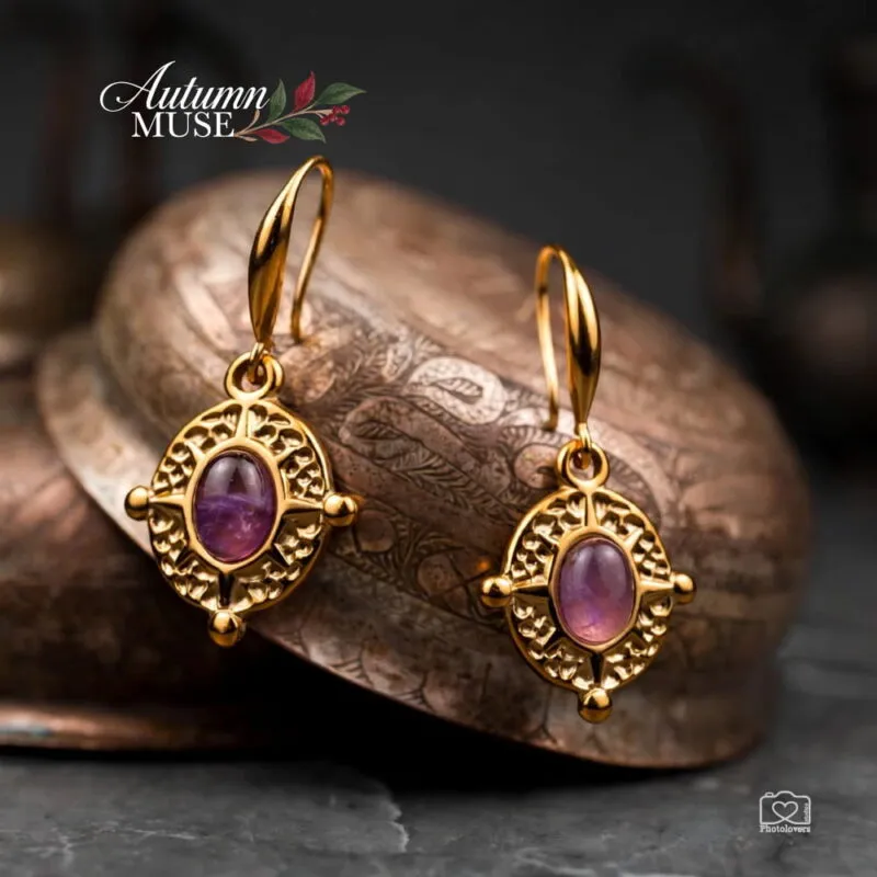 Ατσάλινα κρεμαστά σκουλαρίκια Theodora Earrings σε χρυσό χρώμα, με οβάλ μωβ αμέθυστο και περίτεχνο διάτρητο πλαίσιο