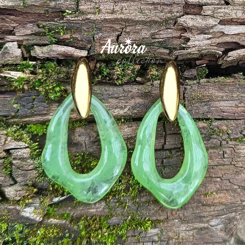 Αναδείξτε τη φινέτσα σας με τα Emerald Drop Earrings σε πράσινο χρώμα με χρυσό φινίρισμα. Κατασκευασμένα από υψηλής ποιότητας ανοξείδωτο ατσάλι, συνδυάζουν την ανθεκτικότητα με την κομψότητα ενός διαχρονικού κοσμήματος. Tο κρεμαστό δάκρυ από κόκκαλο σε έντονο πράσινο χρώμα προσθέτει κίνηση και εκλεπτυσμένη λάμψη σε κάθε σας εμφάνιση. Η αντίθεση του ζεστού χρυσού με το ζωηρό πράσινο δημιουργεί ένα statement κομμάτι που μαγνητίζει τα βλέμματα. BF02.00028